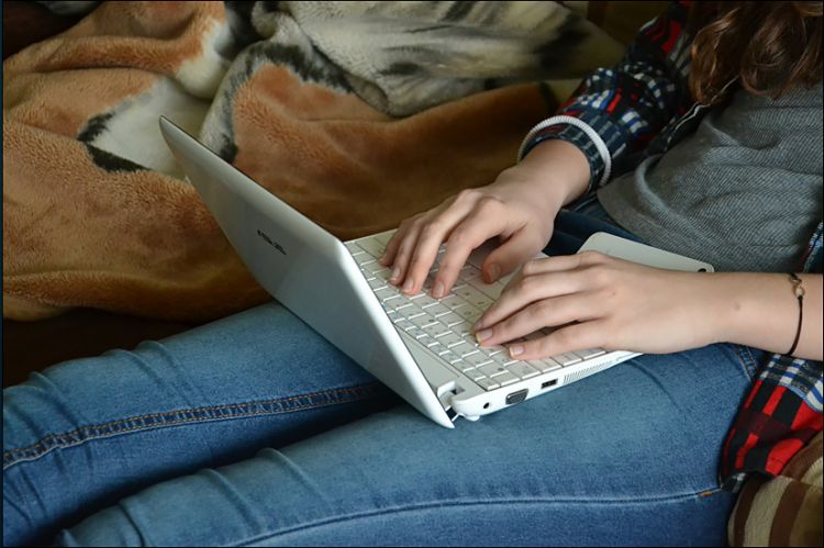 Image of a student at home typing on a laptop computer