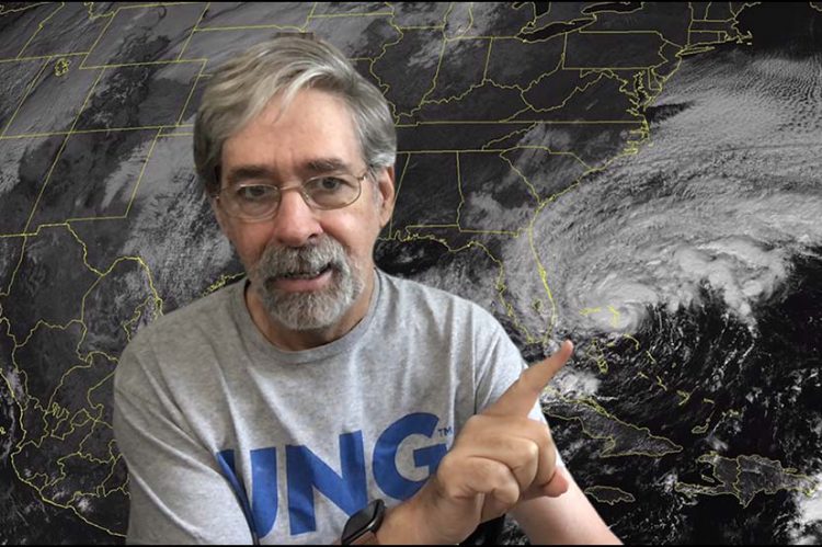 man in front of weather map